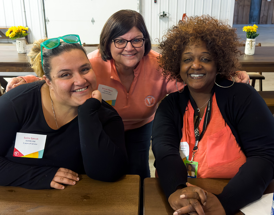 Image of three VGM Employee Owners smiling at table together