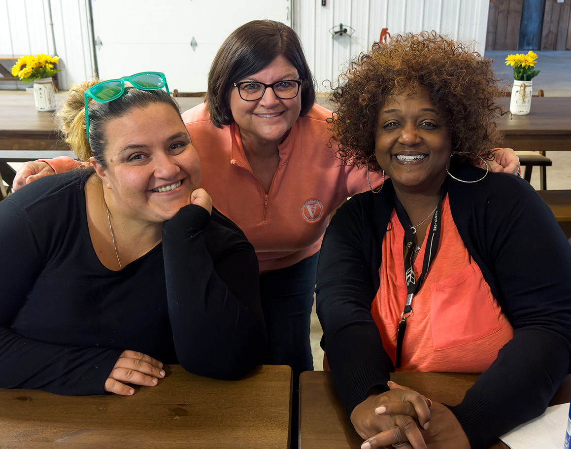 Image of three VGM Employee Owners smiling at table together